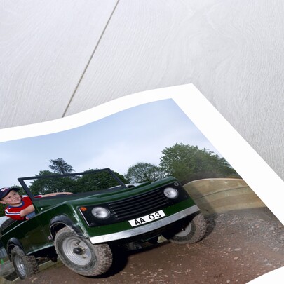 Child driving a toy Land Rover by Unknown