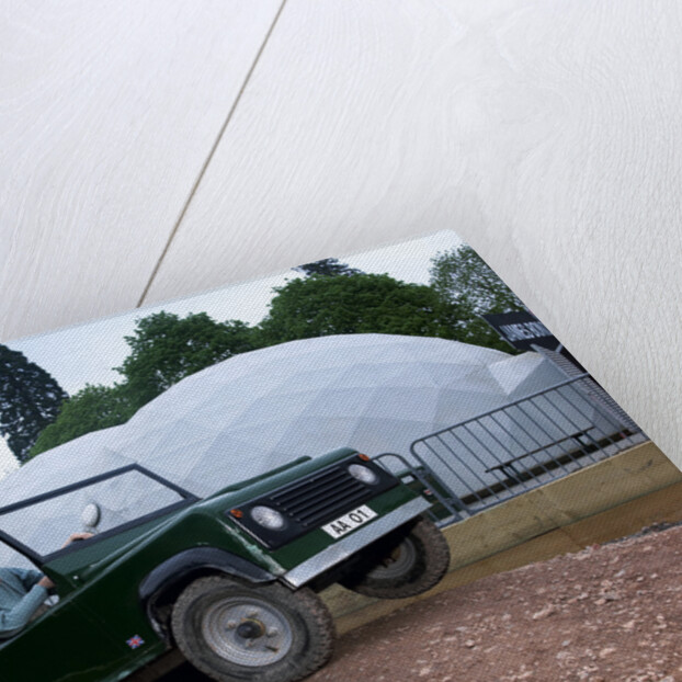 Child driving a toy Land Rover by Unknown