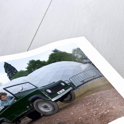 Child driving a toy Land Rover by Unknown