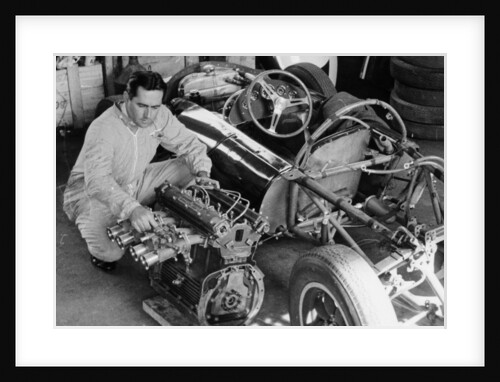Jack Brabham inspecting the engine of a car by Unknown