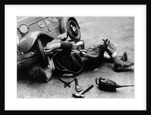 Michael Ware repairing his pedal car by Unknown