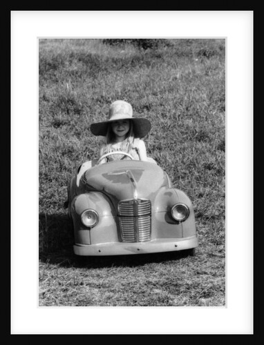 Girl in a 1948 vintage Austin J40 pedal car by Unknown