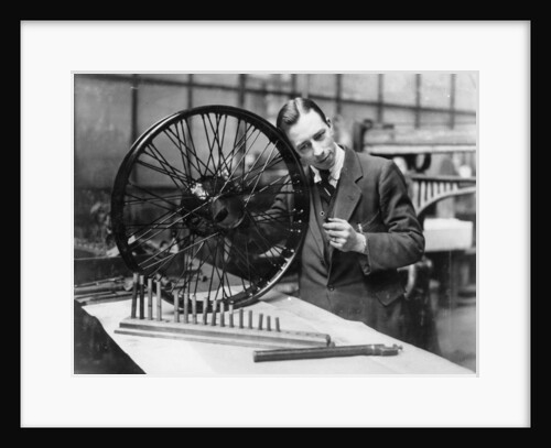 A man in a workshop with a wheel by Unknown