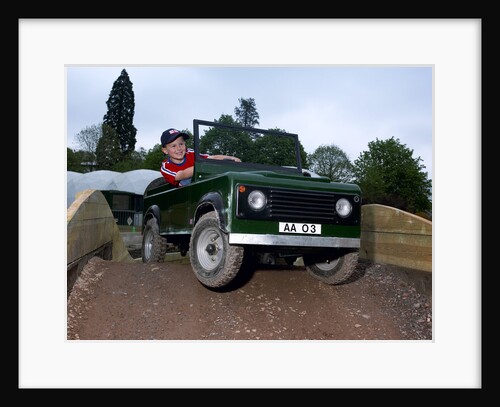 Child driving a toy Land Rover by Unknown
