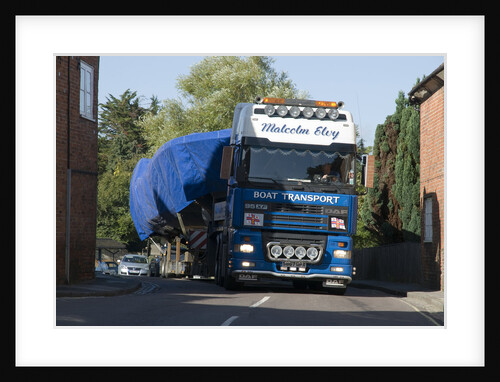 DAF 95 XF wide load truck carrying a life boat through a small village by Anonymous