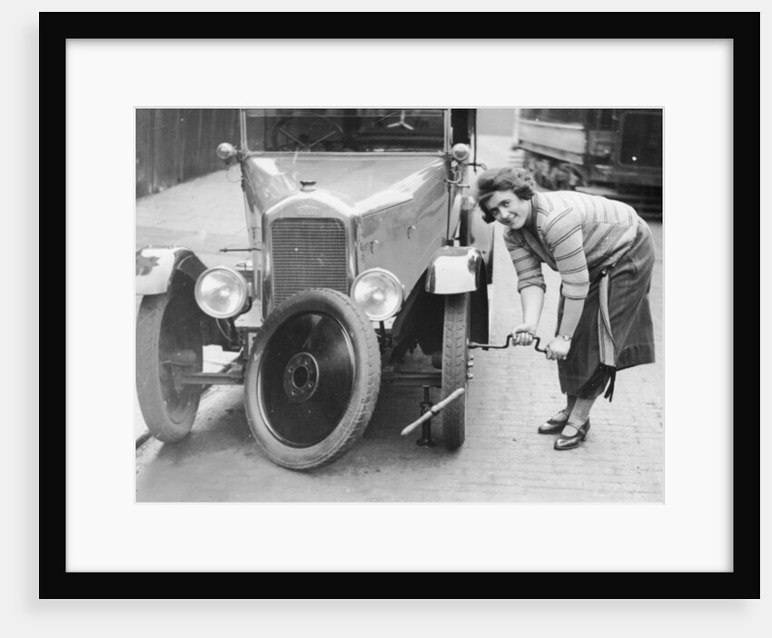 Ivy Cummings changing a tyre on a 1925 Singer 10/26, London, c1925 by Unknown