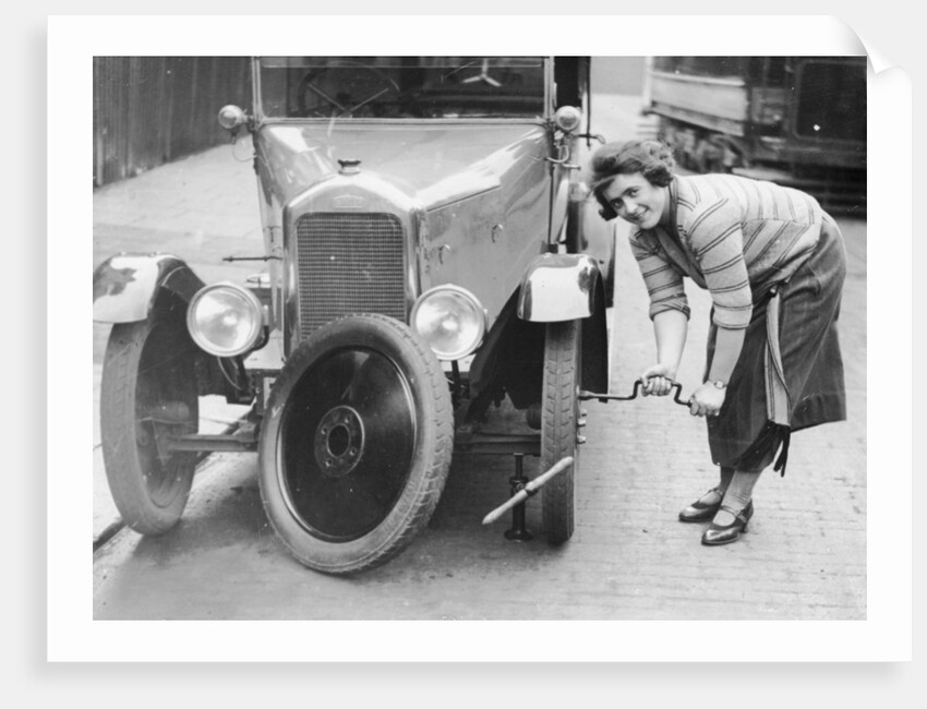 Ivy Cummings changing a tyre on a 1925 Singer 10/26, London, c1925 by Unknown