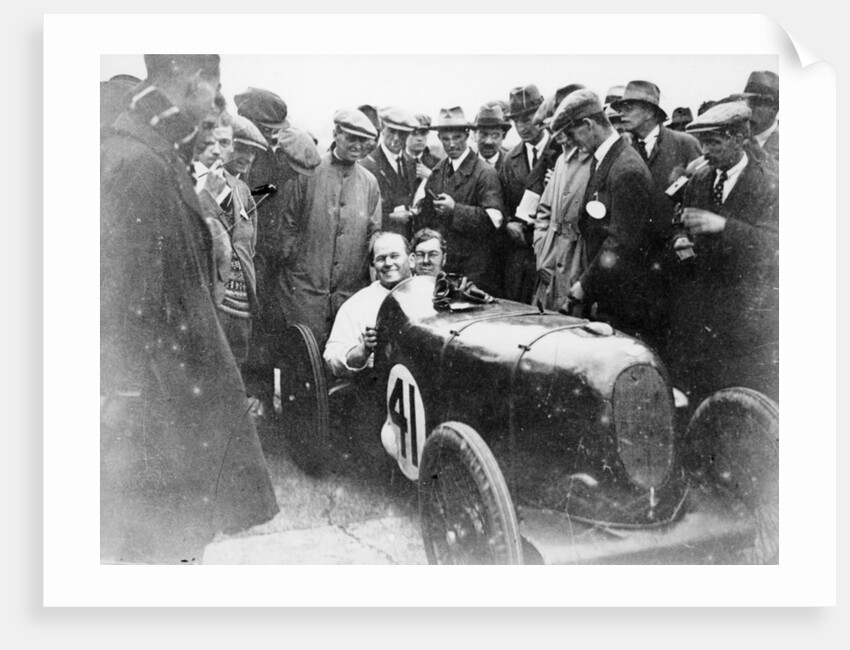 Gordon Taylor in a racing car surrounded by a crowd of men by Unknown