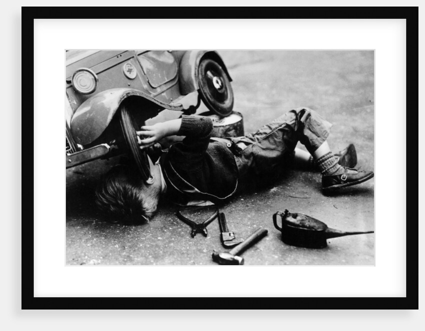 Michael Ware repairing his pedal car by Unknown