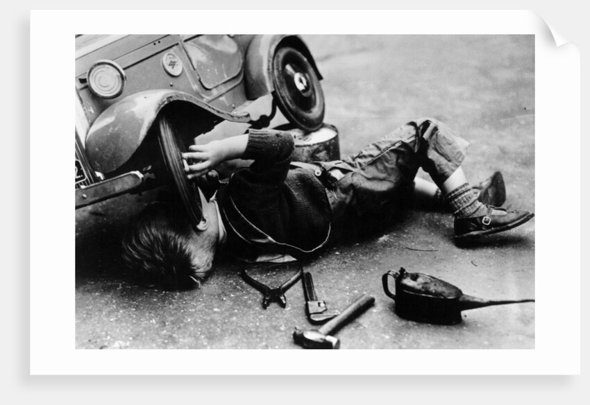 Michael Ware repairing his pedal car by Unknown