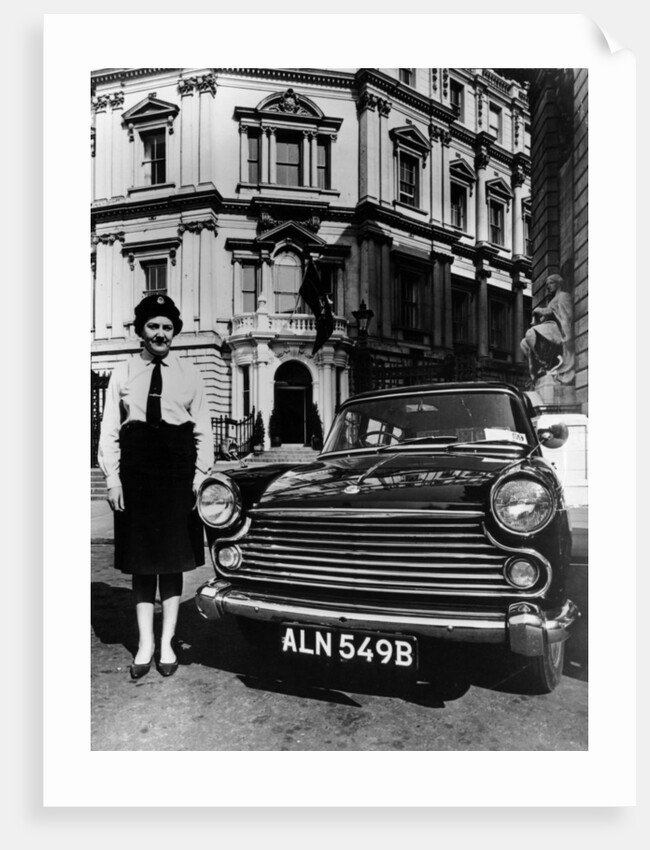 Female chauffeur standing by a 1964 Morris Oxford, 1964 by Unknown