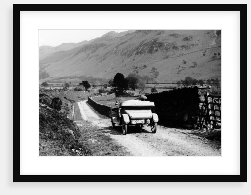 A vintage car travelling along a lane through the Lake District, Cumbria, 1920s by Unknown