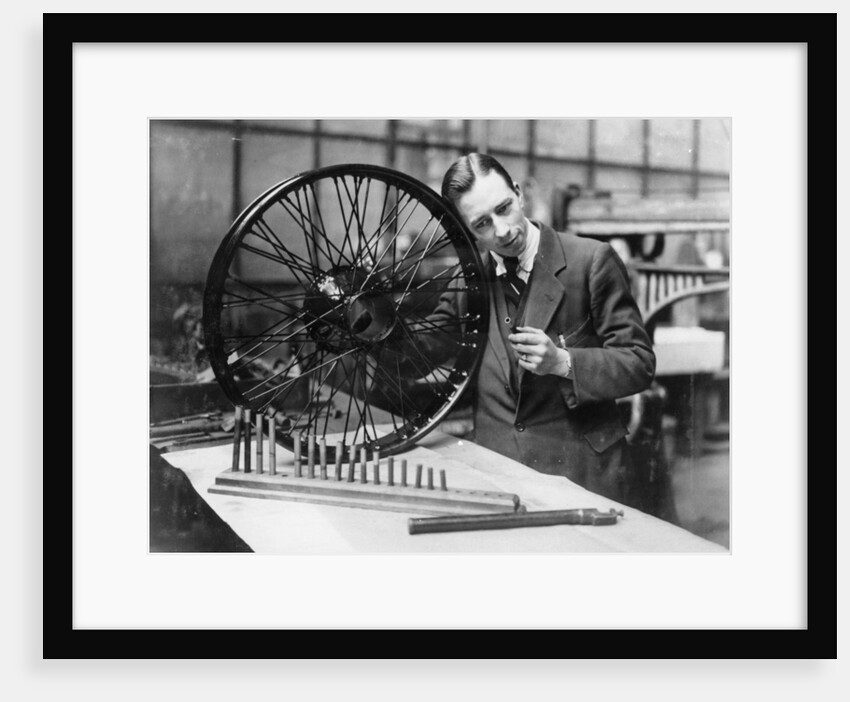 A man in a workshop with a wheel by Unknown