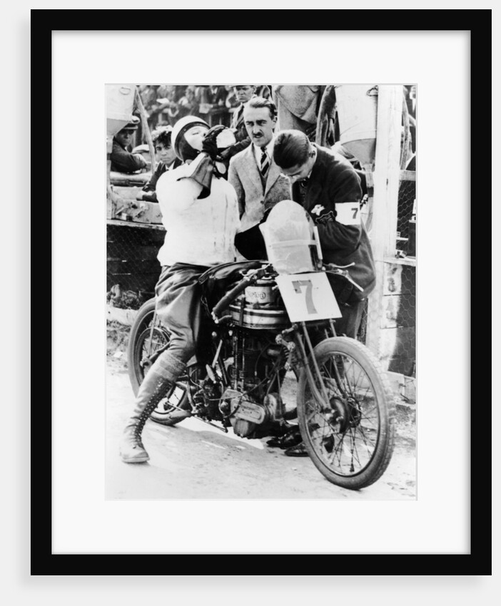Van Horne taking a drink whilst on his Norton bike by Unknown