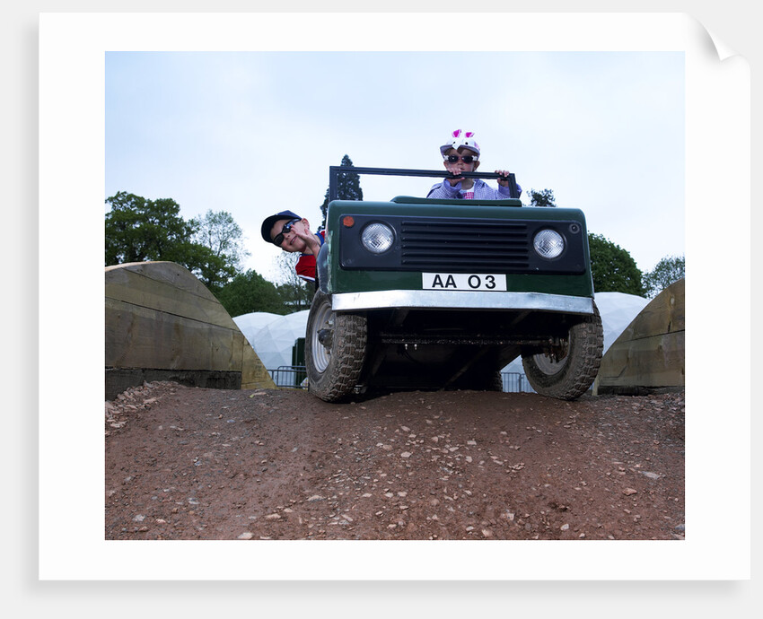 Child driving a toy Land Rover by Unknown