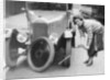 Ivy Cummings changing a tyre on a 1925 Singer 10/26, London, c1925 by Unknown