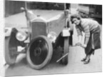 Ivy Cummings changing a tyre on a 1925 Singer 10/26, London, c1925 by Unknown