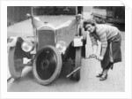 Ivy Cummings changing a tyre on a 1925 Singer 10/26, London, c1925 by Unknown