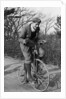 A young Lord Nuffield riding a bicycle down a country lane by Unknown