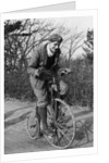 A young Lord Nuffield riding a bicycle down a country lane by Unknown