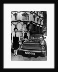 Female chauffeur standing by a 1964 Morris Oxford, 1964 by Unknown
