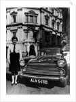 Female chauffeur standing by a 1964 Morris Oxford, 1964 by Unknown