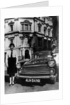 Female chauffeur standing by a 1964 Morris Oxford, 1964 by Unknown