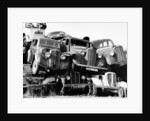 Old cars piled up in a scrapyard, Britain by Unknown