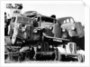 Old cars piled up in a scrapyard, Britain by Unknown