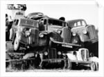 Old cars piled up in a scrapyard, Britain by Unknown