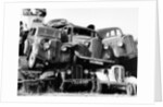 Old cars piled up in a scrapyard, Britain by Unknown