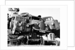 Old cars piled up in a scrapyard, Britain by Unknown