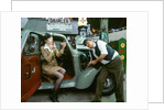Mechanic with lady driver doing her make up, 1930's Hillman Minx by Unknown