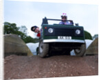 Child driving a toy Land Rover by Unknown