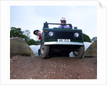 Child driving a toy Land Rover by Unknown