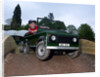 Child driving a toy Land Rover by Unknown