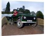 Child driving a toy Land Rover by Unknown