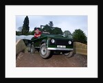 Child driving a toy Land Rover by Unknown
