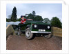 Child driving a toy Land Rover by Unknown