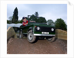 Child driving a toy Land Rover by Unknown