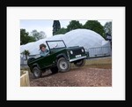 Child driving a toy Land Rover by Unknown