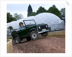 Child driving a toy Land Rover by Unknown