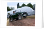 Child driving a toy Land Rover by Unknown