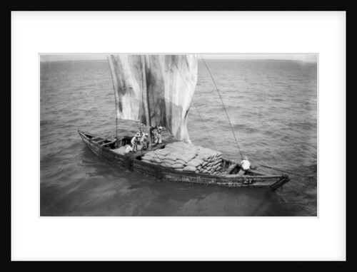 Indigenous boat at sea, laden with sacks by unknown