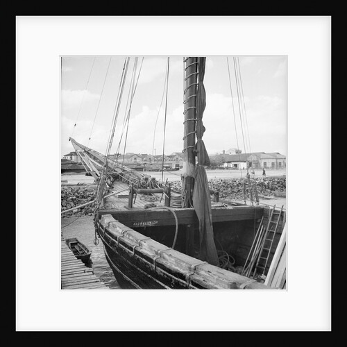 The forepart of a Tongkung type junk alongside a landing stage at Singapore by David Watkin Waters