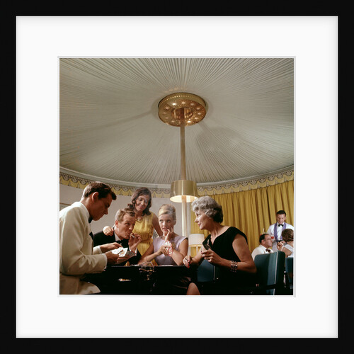 Passengers in smart evening dress, aboard an unspecified cruise liner, enjoy the thrilling distraction of a card game by Marine Photo Service