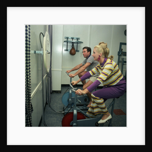 After all the lunches and cocktail evenings, a little exercise is just the thing: two passengers use exercise bikes in the gym of an unspecified cruise liner by Marine Photo Service