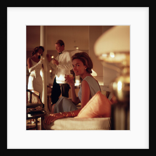 A smartly attired female passenger enjoys an evening tipple aboard an unspecified cruise ship by Marine Photo Service
