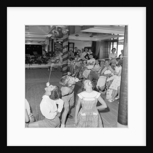 Three children in the "Apple Eating" contest, possibly in the ballroom of the 'Chusan' (1950) by Marine Photo Service