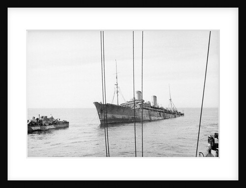 Photograph of 'Windsor Castle' sinking in 1943. Port bow view well down by the stern with the escort destroyer 'Farndale' (1940) near the bow. by Lt EJ Manners